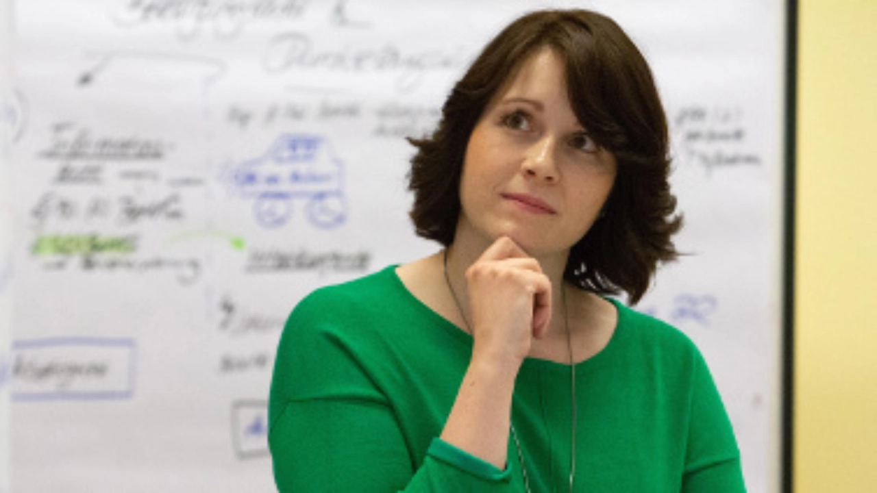 Eine nachdenklich blickende Frau in einem Seminar.