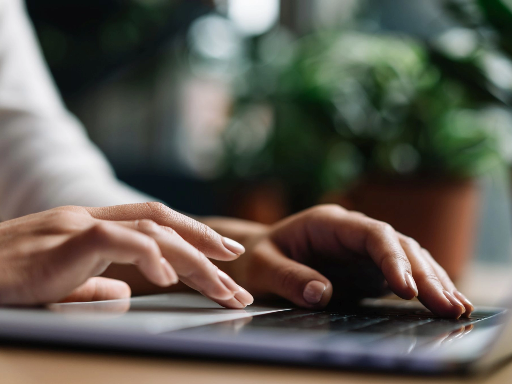 Hände tippen auf der Tastatur eines Laptops